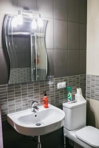 a bathroom with a sink and a mirror and a toilet at Сozy Apartment In Great Location in Rīga