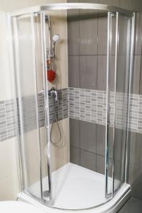 a shower with a glass door in a bathroom at Сozy Apartment In Great Location in Rīga