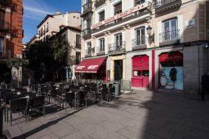 a street with tables and chairs in front of a building at Hostal Santa Cruz in Madrid