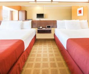 a hotel room with two beds and a television at Microtel Inn by Wyndham Stillwater in Stillwater