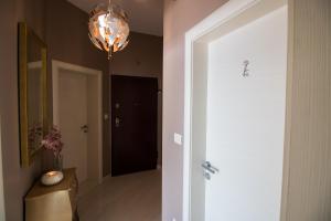 a hallway with a white door and a chandelier at Incantesimo luxury penthouse in Mimice +64 photos