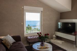 a living room with a couch and a large window at Incantesimo luxury penthouse in Mimice