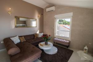 a living room with a brown couch and a window at Incantesimo luxury penthouse in Mimice