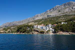 a house on a hill next to a body of water at Incantesimo luxury penthouse in Mimice