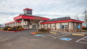 a building with a parking lot in front of it at Bridgeway Inn & Suites - Portland Airport in Gresham