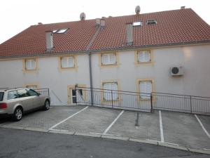 a building with a car parked in a parking lot at Apartment Antoncic in Dramalj