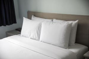 a white bed with a white comforter and pillows at Ocean Park Hotel in Los Angeles