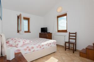 a bedroom with a bed and a chair at Apartments Athos in Rabac