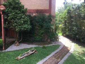 um jardim com um caminho ao lado de um edifício em Riacho Das Pedras Pousada em Gonçalves