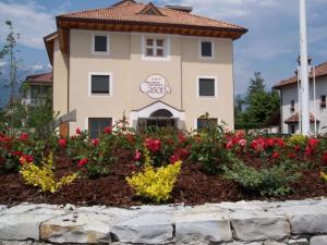 a building with a flower garden in front of it at Hotel Ristorante La Casona in Feltre