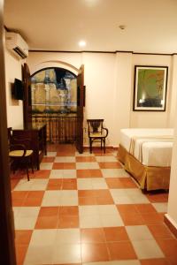 een slaapkamer met een bed en een dambordvloer bij Hotel La Recolección in León