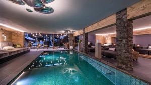 una piscina nel mezzo di una stanza con soggiorno di Alpin Garden Luxury Maison & SPA - Adults Only a Ortisei
