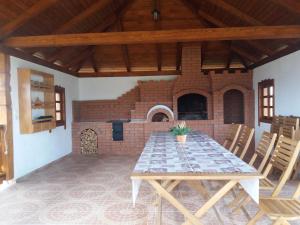 a dining room with a table and a brick oven at Pensiunea Obcina Mare in Cacica