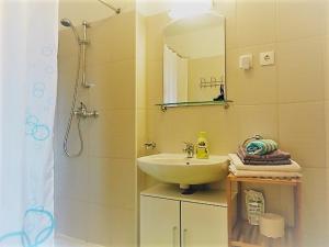 a bathroom with a sink and a shower with a mirror at Belic Vinko- house in Jelsa