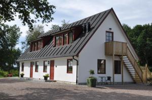 una casa blanca con techo de gambrel en Hjortsby Torp en Helsingborg