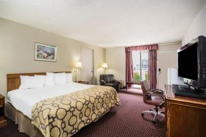 a hotel room with a bed and a flat screen tv at Baymont by Wyndham Johnson City in Johnson City