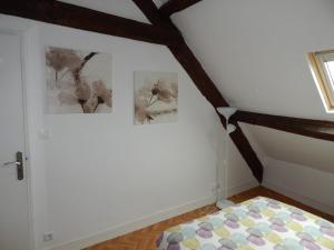 a bedroom with two pictures on the wall and a bed at Au cœur du centre historique in Bayeux