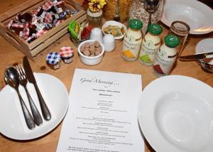 a table with plates and utensils and a menu at The Crown Inn in West Down