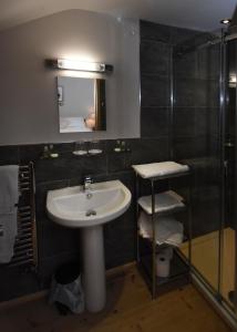 a bathroom with a sink and a mirror and a shower at The Crown Inn in West Down