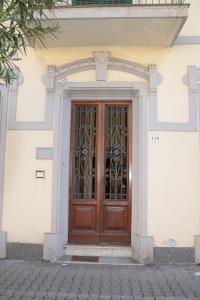 uma porta de madeira com um portão de metal num edifício em Villino Silvia em Viareggio