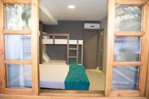 a bunk bed in a room with two windows at REF House Barra Da Tijuca in Rio de Janeiro