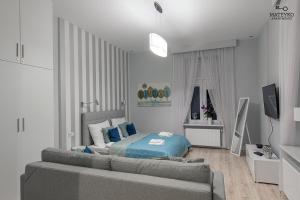 Habitación blanca con cama y sofá en Mateyko Apartment en Cracovia