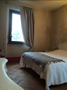 1 dormitorio con cama, ventana y bañera en Tenuta di Vico Moricino, en Anagni