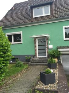 ein grünes Haus mit einer steinernen Einfahrt davor in der Unterkunft Casa Verde Kassel in Kassel