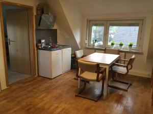 a kitchen with a table and chairs and a kitchen with a counter at Casa Verde Kassel in Kassel