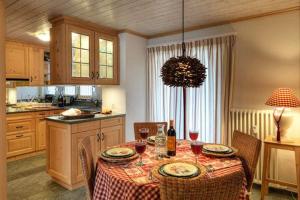 una cocina con una mesa con copas de vino. en Chalet Drusa, en Klosters Serneus