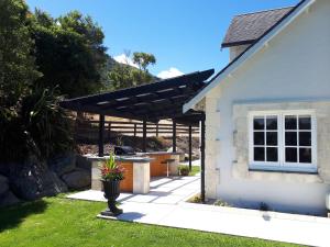 a house with a black pergola in a yard at Sky Harbour in Kaikoura