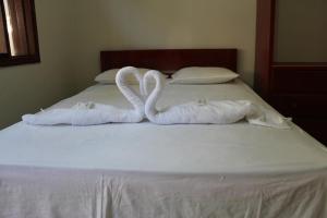dos toallas con forma de cisnes sentados en una cama en Tengana Hospedaje y Tours, en Tarapoto