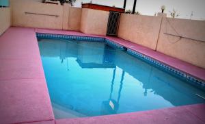 a swimming pool with a pink and blue at Budget Inn Parker in Parker