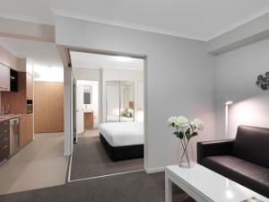 una camera d'albergo con letto e soggiorno di Oaks Mackay Rivermarque Hotel a Mackay