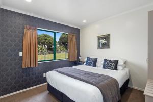 Un dormitorio con una cama grande y una ventana en Belmont Motor Lodge, en Porirua