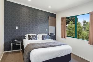 Un dormitorio con una cama grande y una ventana en Belmont Motor Lodge en Porirua
