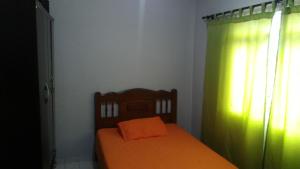 - une chambre avec un lit doté d'un oreiller orange dans l'établissement Nossa Casa, à Cunha