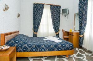 um quarto com uma cama com um edredão azul em Manousos' Rooms em Galissas