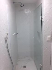y baño con ducha y puerta de cristal. en Ondina Apart Hotel en Salvador