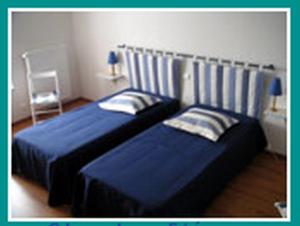 - une chambre avec deux lits et une chaise dans l'établissement Les Quatre Saisons, à Moitron-sur-Sarthe