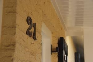 una pared de piedra con un número metálico. en Beck's Bed and Breakfast en Kaatsheuvel