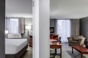 モントリオールにあるホテル フォーブル モントリオール センターヴィル ダウンタウンのベッドとデスクが備わるホテルルームです。