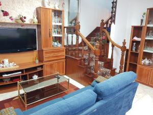 a living room with a blue couch and a television at Virginia Redondela in Redondela