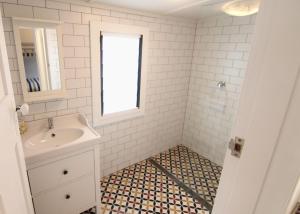 a white bathroom with a sink and a window at Good Vibes, 18 East Street in Crescent Head