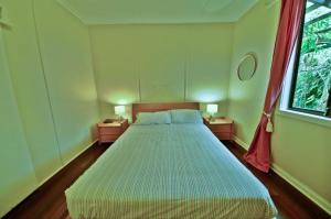 ein Schlafzimmer mit einem großen Bett mit zwei Nachttischen in der Unterkunft Rosemaree, 24 East Street in Crescent Head