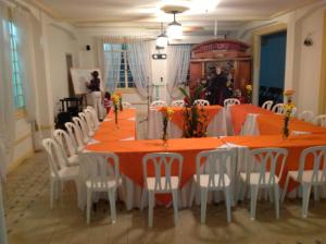 a dining room with orange tables and white chairs at Hotel Savoy in Cali