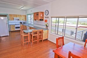a kitchen with a table and some chairs in a room at Bella Vista, 9 East Street in Crescent Head