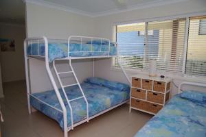 a bedroom with two bunk beds and a window at Beach Club 1, 5 Gowing Street in Crescent Head