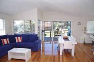 a living room with a blue couch and a white table at Beach Club 1, 5 Gowing Street in Crescent Head