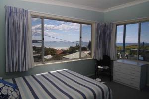 a bedroom with a bed and a large window at Clareview, 8 Korogora Street in Crescent Head